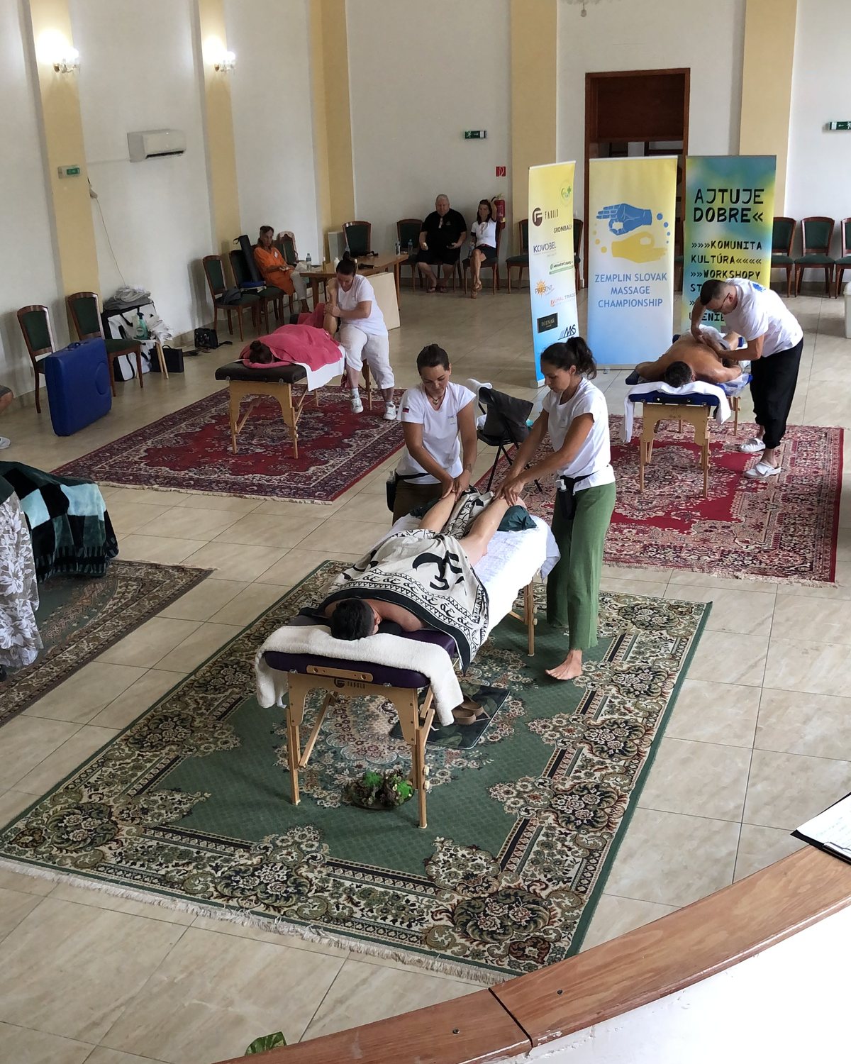Súťažiaci maséri pri práci v sále počas Zemplín Slovakia Massage Championship 2024 v Michalovciach